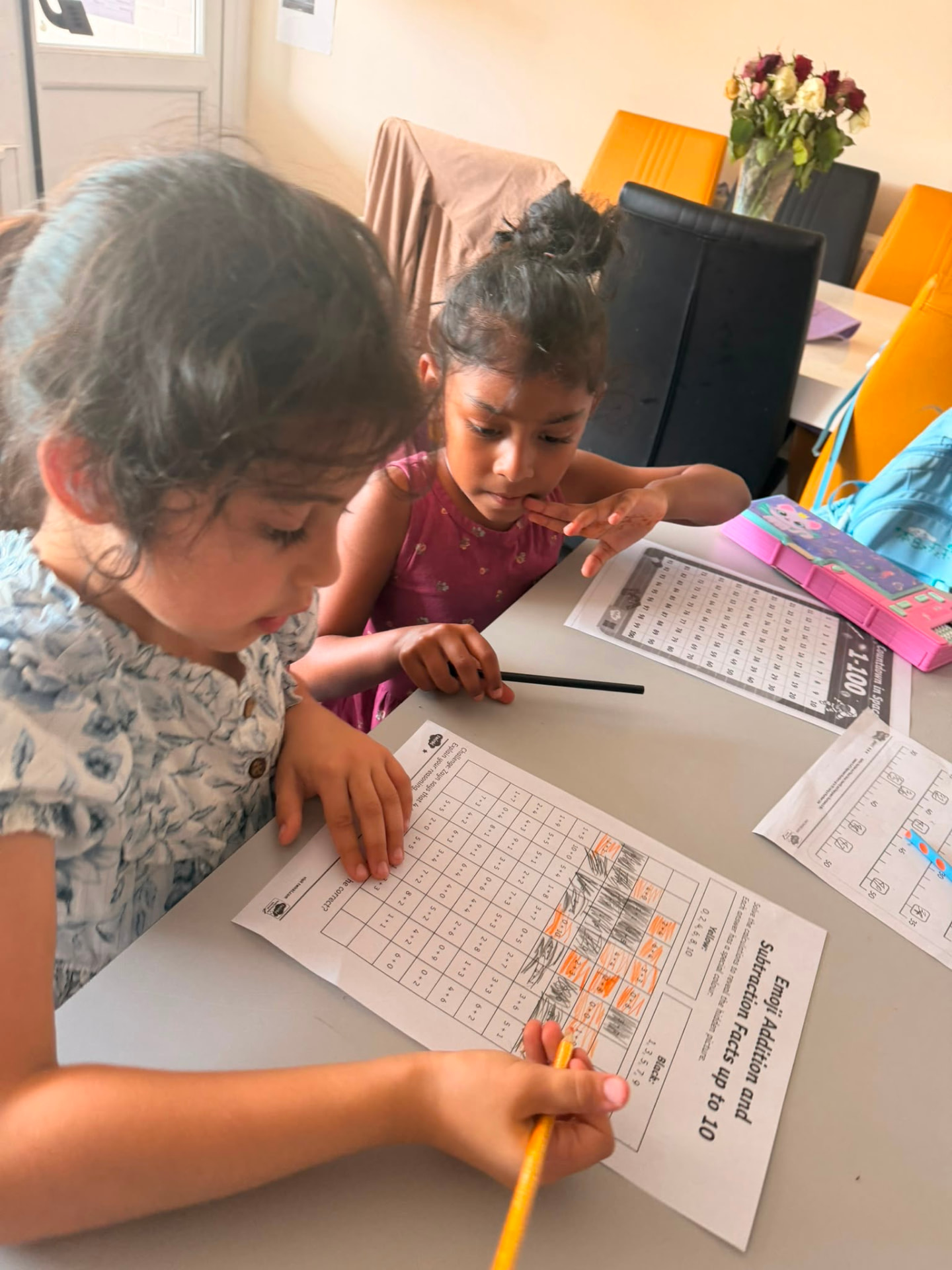 Two young girls working together on a maths activity sheet at a Be-Etiquette homework club